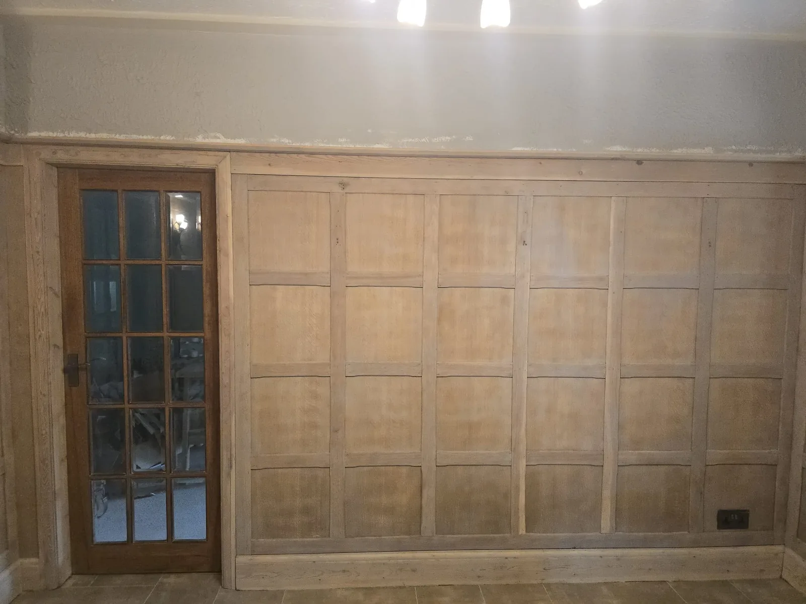 Restored timber panelling and glazed door with dark coating removed and joinery detail preserved