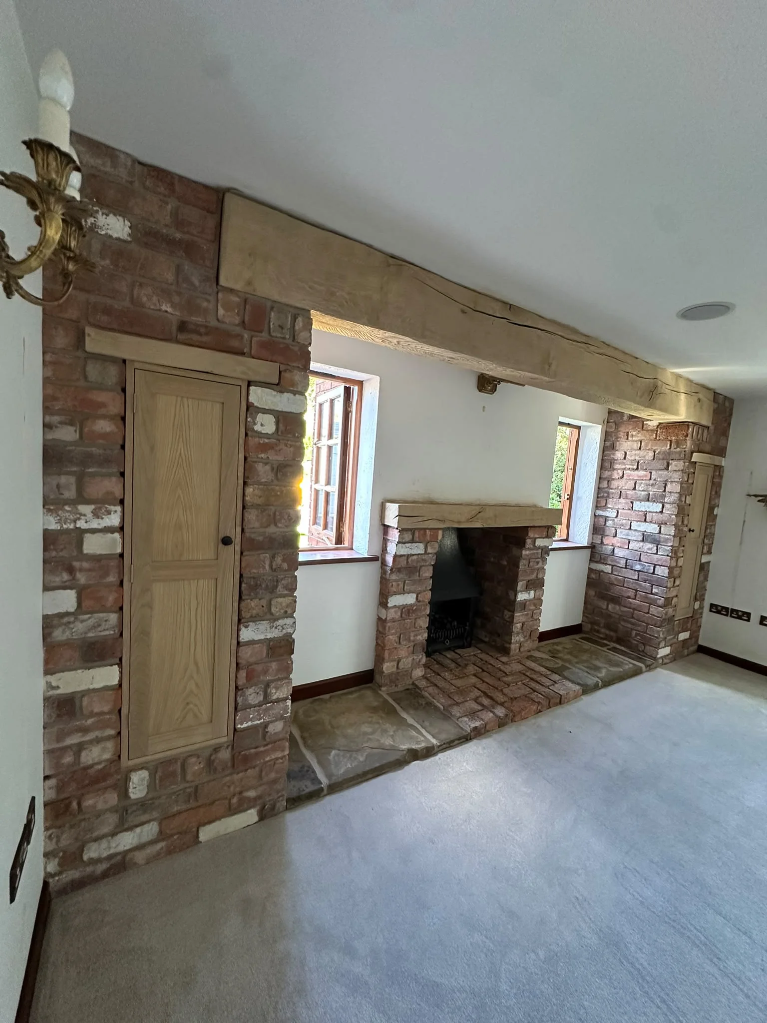 Restored fireplace feature after coating removal with lighter natural timber and brick textures